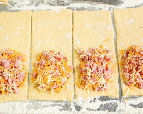 crescent dough strips with ham and cheese mixture on top