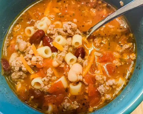 pasta fagioli soup in bowl with silver spoon